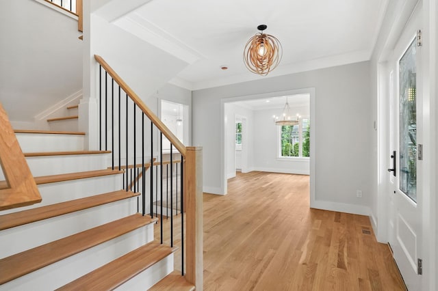 2 Lavender Ln, Rye, NY 10580 - entrance foyer with a chandelier, stairway, light wood finished floors, baseboards, and crown molding