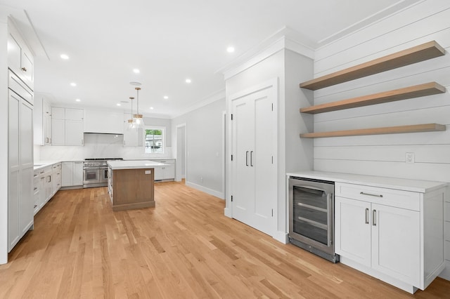 2 Lavender Ln, Rye, NY 10580 - kitchen featuring wine cooler, range with two ovens, ornamental molding, open shelves, and a kitchen island