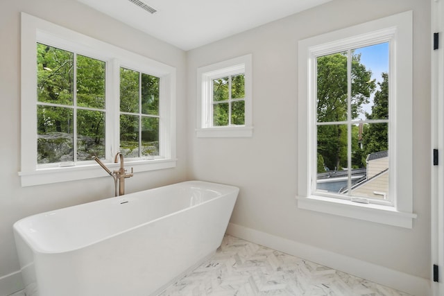 2 Lavender Ln, Rye, NY 10580 - bathroom featuring healthy amount of natural light, a freestanding tub, baseboards, and marble finish flooring