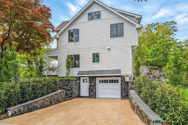 2 Lavender Ln, Rye, NY 10580 - view of side of property with stone siding, a garage, board and batten siding, and driveway