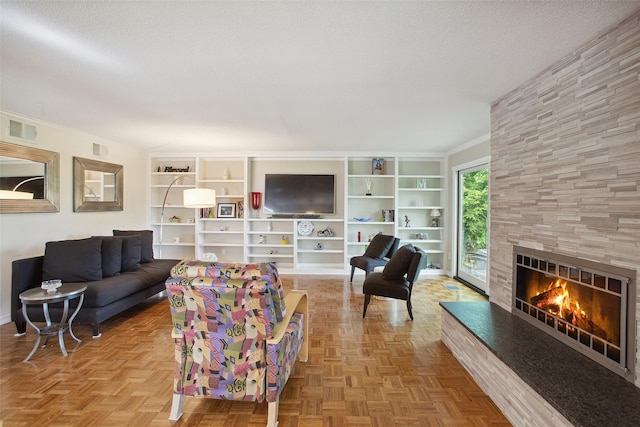 304 Heritage Hls Unit C, Somers, NY 10589 - living room featuring a fireplace, a textured ceiling, built in shelves, and crown molding