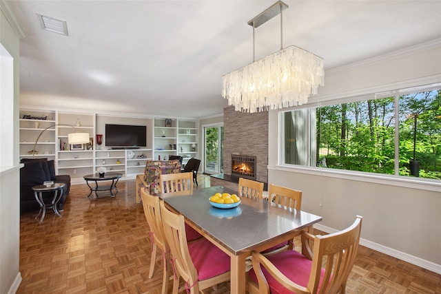 304 Heritage Hls Unit C, Somers, NY 10589 - dining area with a fireplace, baseboards, a chandelier, and ornamental molding