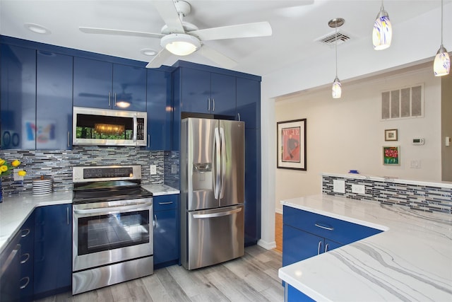 304 Heritage Hls Unit C, Somers, NY 10589 - kitchen featuring stainless steel appliances, blue cabinetry, decorative backsplash, and light stone counters
