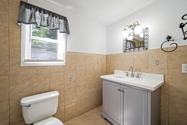 218 Beaver Dr, Mastic Beach, NY 11951 - bathroom with tile walls, toilet, vanity, tile patterned flooring, and a wainscoted wall