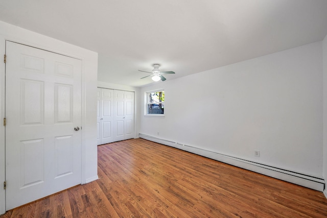 218 Beaver Dr, Mastic Beach, NY 11951 - unfurnished bedroom with a baseboard heating unit, wood finished floors, a closet, a ceiling fan, and baseboards