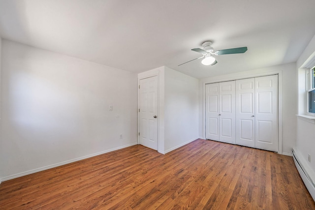218 Beaver Dr, Mastic Beach, NY 11951 - unfurnished bedroom with a baseboard heating unit, wood finished floors, a closet, and a ceiling fan