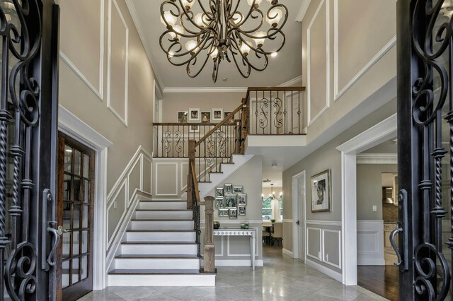 2 Maize Ct, Melville, NY 11747 - foyer with a chandelier, a decorative wall, stairway, crown molding, and a high ceiling