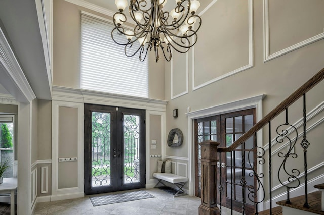 2 Maize Ct, Melville, NY 11747 - foyer featuring french doors, a decorative wall, a high ceiling, a chandelier, and plenty of natural light