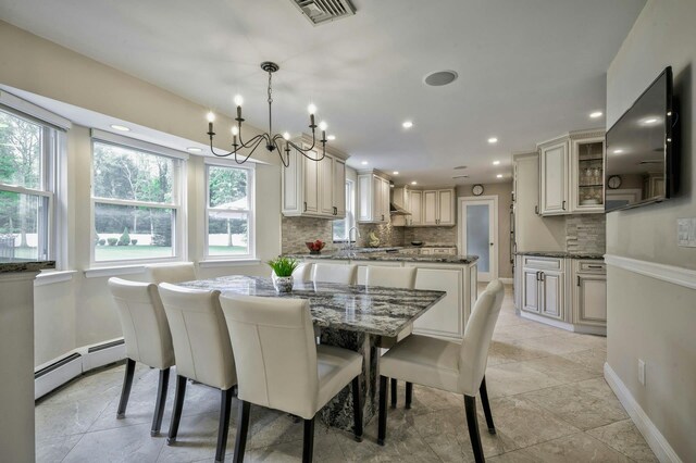 2 Maize Ct, Melville, NY 11747 - dining area featuring a baseboard radiator, baseboards, a chandelier, recessed lighting, and light stone finish floors