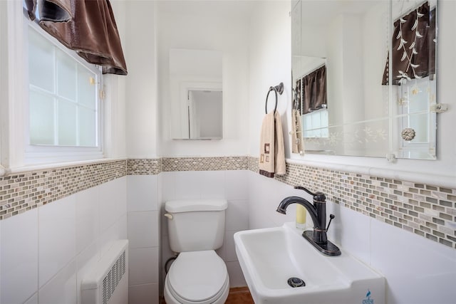 11 Spruce St, Garden City, NY 11530 - half bathroom featuring radiator, tile walls, and a wainscoted wall
