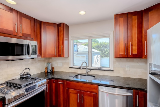 11 Spruce St, Garden City, NY 11530 - kitchen featuring appliances with stainless steel finishes, dark stone countertops, decorative backsplash, reddish brown cabinets, and recessed lighting