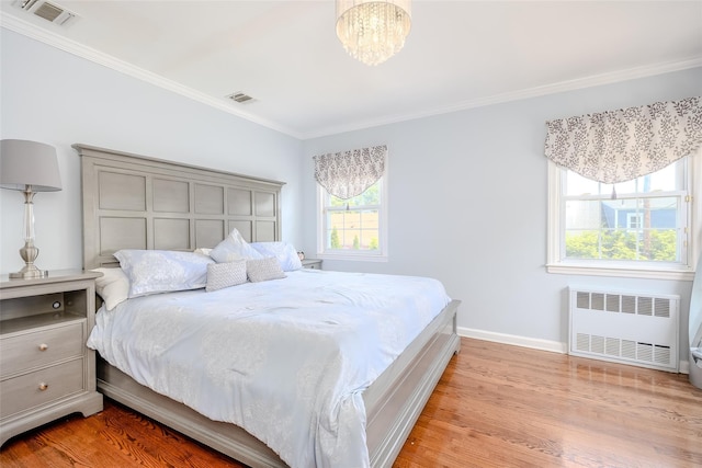 11 Spruce St, Garden City, NY 11530 - bedroom featuring radiator, crown molding, light wood-type flooring, and a chandelier