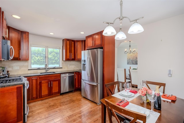 11 Spruce St, Garden City, NY 11530 - kitchen with stainless steel appliances, dark countertops, a chandelier, backsplash, and light wood-style floors