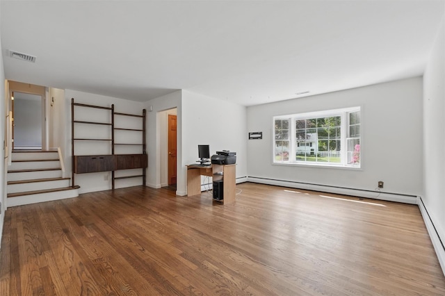 55 Stephanie Ln, Poughkeepsie, NY 12603 - unfurnished living room featuring a baseboard heating unit, wood finished floors, and stairs