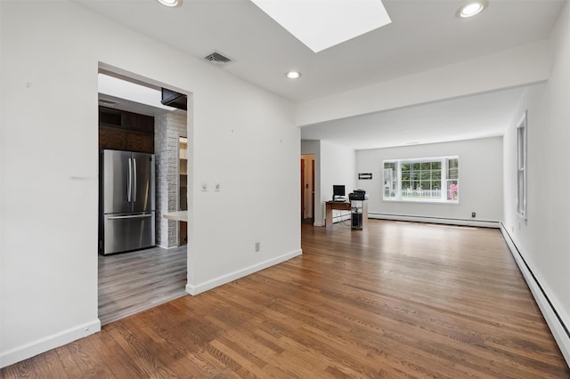 55 Stephanie Ln, Poughkeepsie, NY 12603 - unfurnished living room featuring wood finished floors, a baseboard heating unit, a skylight, recessed lighting, and baseboards