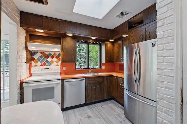 55 Stephanie Ln, Poughkeepsie, NY 12603 - kitchen with appliances with stainless steel finishes, light countertops, decorative backsplash, light wood-style floors, and a skylight