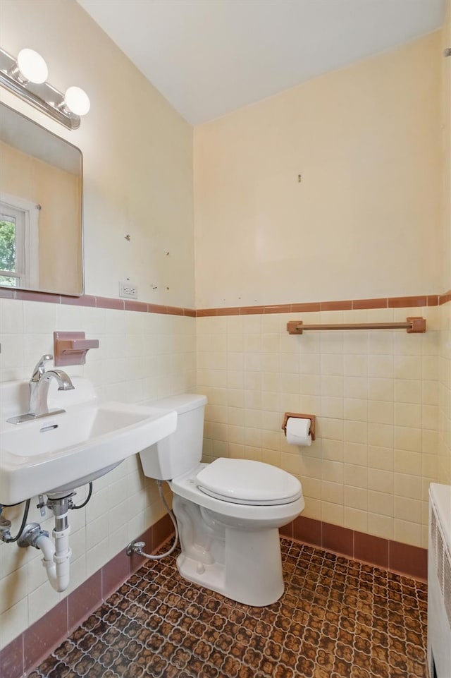 55 Stephanie Ln, Poughkeepsie, NY 12603 - bathroom with tile walls, toilet, tile patterned floors, a wainscoted wall, and a sink
