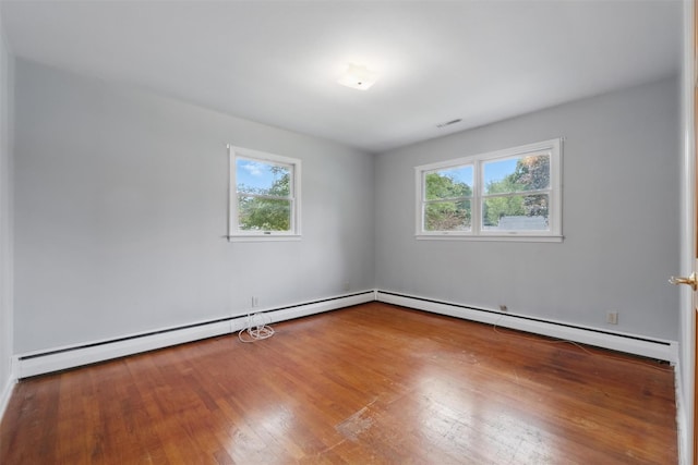 55 Stephanie Ln, Poughkeepsie, NY 12603 - empty room featuring plenty of natural light, wood finished floors, and a baseboard heating unit