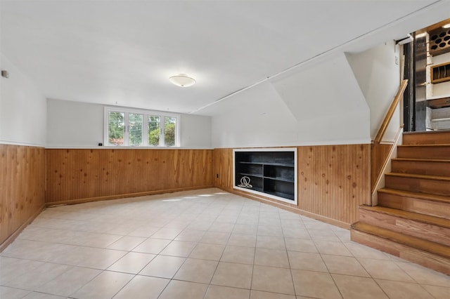 55 Stephanie Ln, Poughkeepsie, NY 12603 - empty room with a wainscoted wall, wood walls, stairway, and light tile patterned flooring