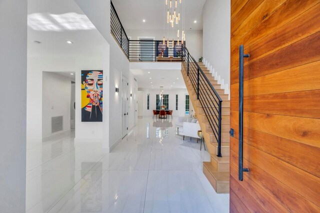 50 Gristmill Ln, Great Neck, NY 11023 - tiled foyer entrance featuring stairs, a chandelier, a towering ceiling, and recessed lighting