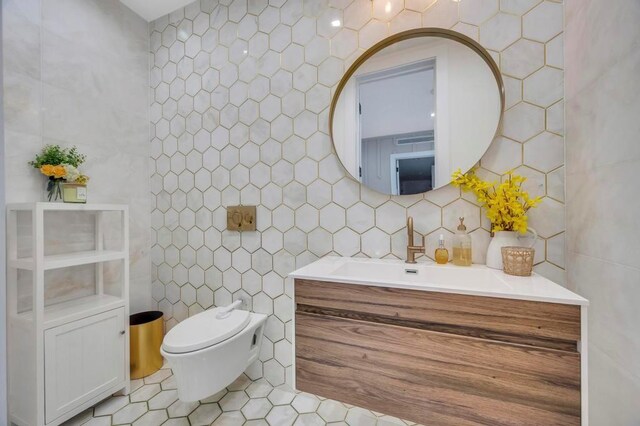 50 Gristmill Ln, Great Neck, NY 11023 - bathroom with tile walls, vanity, tile patterned floors, toilet, and decorative backsplash
