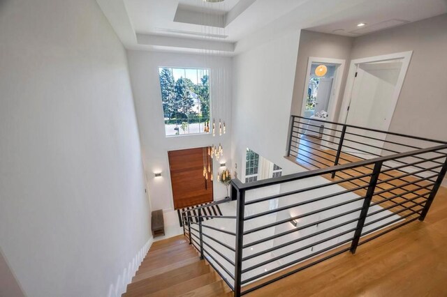 50 Gristmill Ln, Great Neck, NY 11023 - stairs with wood finished floors and a tray ceiling