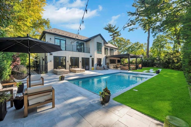 50 Gristmill Ln, Great Neck, NY 11023 - back of property featuring outdoor lounge area, a balcony, stucco siding, and a lawn