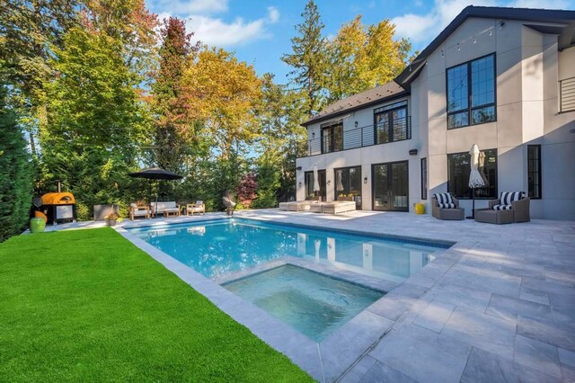 50 Gristmill Ln, Great Neck, NY 11023 - view of swimming pool featuring an outdoor hangout area, a patio area, a lawn, and a pool with connected hot tub
