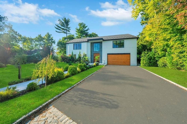 50 Gristmill Ln, Great Neck, NY 11023 - contemporary home with driveway, an attached garage, stucco siding, and a front yard