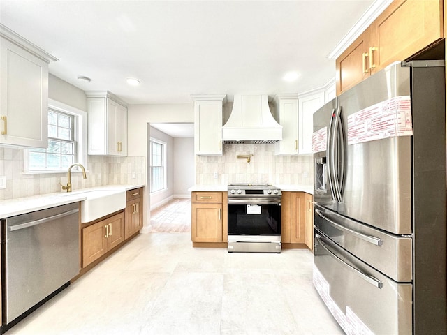 56 Patmore Ave, Yonkers, NY 10710 - kitchen featuring stainless steel appliances, wall chimney range hood, a sink, light countertops, and tasteful backsplash