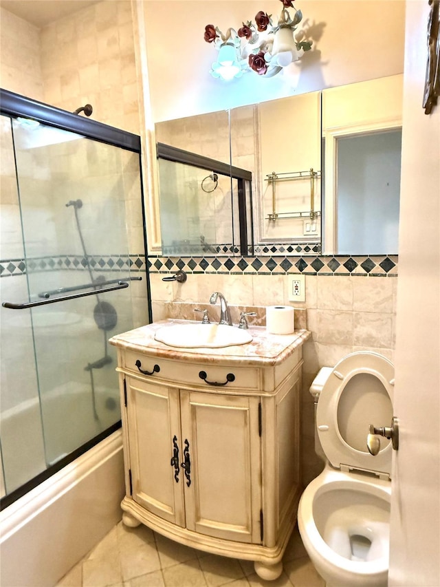 1 Overlook Ave Unit 1L, Great Neck, NY 11021 - full bathroom with tile walls, combined bath / shower with glass door, tile patterned flooring, toilet, and vanity