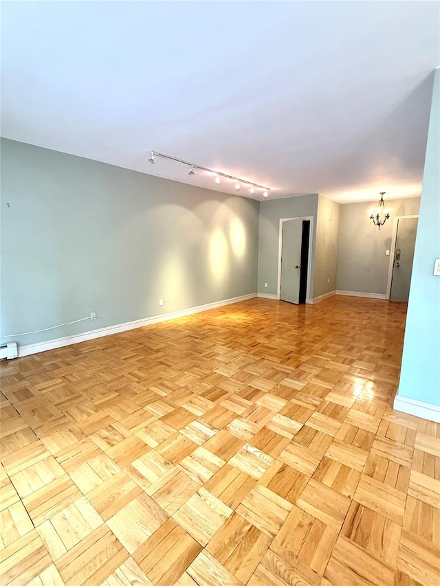 1 Overlook Ave Unit 1L, Great Neck, NY 11021 - spare room featuring rail lighting, baseboards, and a chandelier