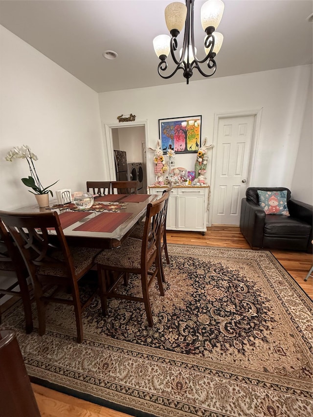 10808 86th St, Ozone Park, NY 11417 - dining space featuring a chandelier, light wood-type flooring, and washer / clothes dryer
