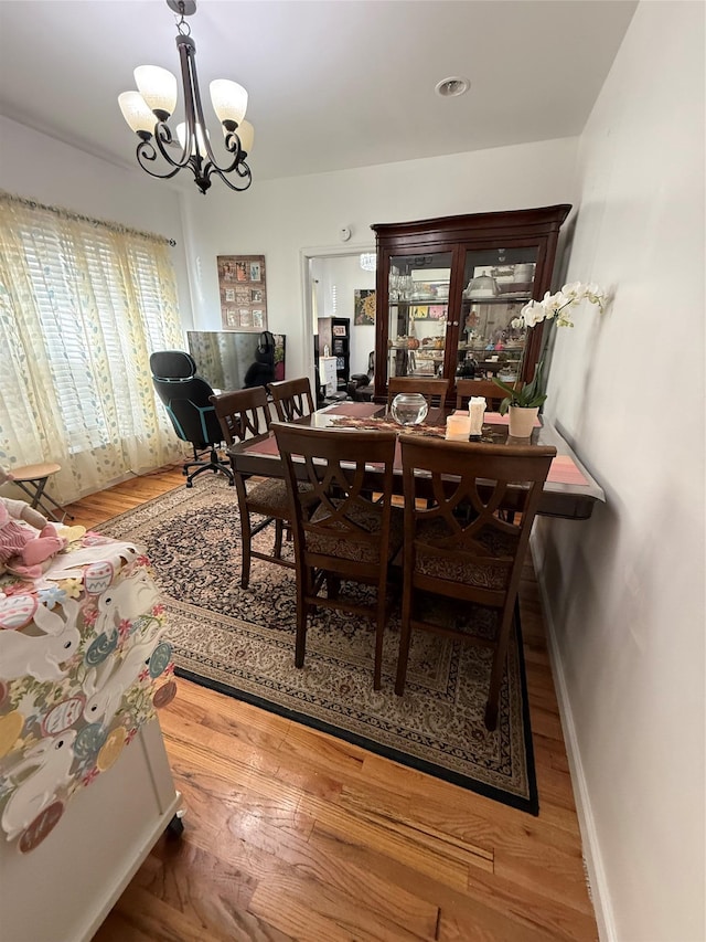 10808 86th St, Ozone Park, NY 11417 - dining area with a chandelier, baseboards, and wood finished floors