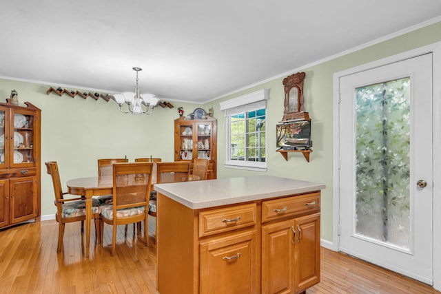 2103 Kings Way Unit 2103, Carmel, NY 10512 - kitchen with light wood-type flooring, a chandelier, light countertops, crown molding, and pendant lighting