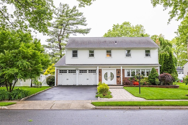 8 Marietta Dr, Westbury, NY 11590 - view of front of home featuring asphalt driveway, a garage, and a front yard