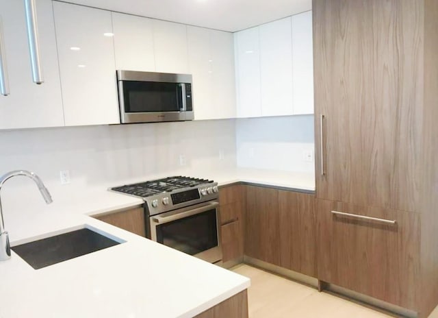 13101 40th Rd Unit 10C, Flushing, NY 11354 - kitchen featuring stainless steel appliances, modern cabinets, a sink, and white cabinetry
