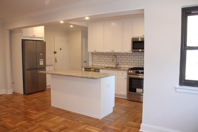 51 White Oak Unit 1H, New Rochelle, NY 10801 - kitchen with stainless steel appliances, a sink, ornamental molding, white cabinetry, and decorative backsplash