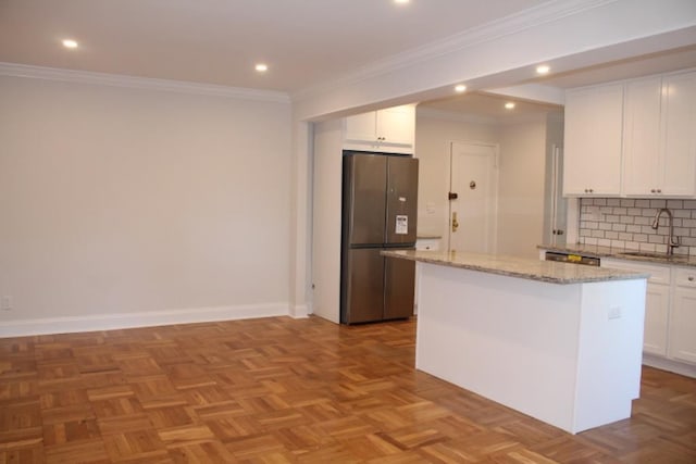 51 White Oak Unit 1H, New Rochelle, NY 10801 - kitchen with freestanding refrigerator, a sink, white cabinets, backsplash, and a center island