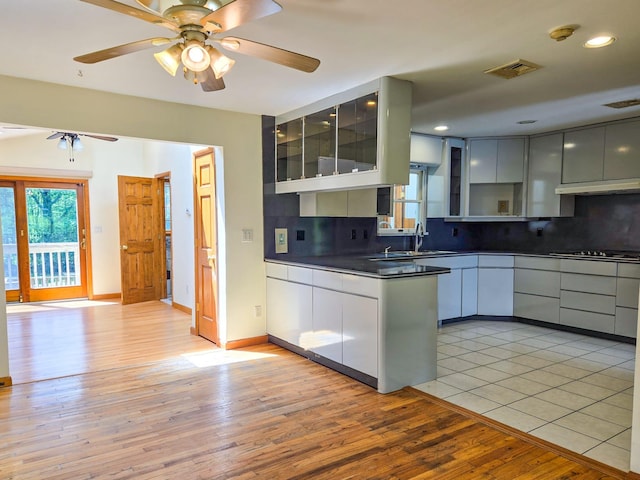 241 Summit Park Rd, Spring Valley, NY 10977 - kitchen featuring a sink, dark countertops, under cabinet range hood, ceiling fan, and backsplash