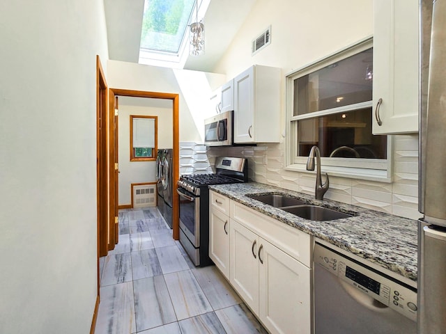 241 Summit Park Rd, Spring Valley, NY 10977 - kitchen featuring appliances with stainless steel finishes, a skylight, a sink, backsplash, and lofted ceiling
