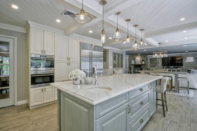 70A Davis Rd, Port Washington, NY 11050 - kitchen featuring stainless steel appliances, a sink, light wood-type flooring, white cabinets, and light stone counters