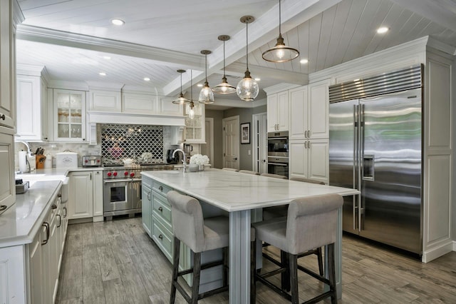 70A Davis Rd, Port Washington, NY 11050 - kitchen featuring premium appliances, white cabinets, wood finished floors, backsplash, and recessed lighting