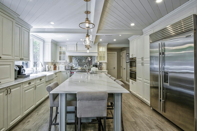 70A Davis Rd, Port Washington, NY 11050 - kitchen with appliances with stainless steel finishes, a sink, wood finished floors, wooden ceiling with exposed beams, and a kitchen breakfast bar
