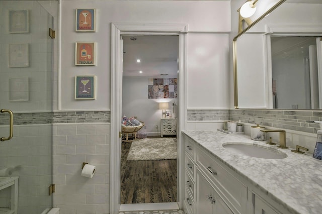 70A Davis Rd, Port Washington, NY 11050 - bathroom featuring vanity, tile walls, wood finished floors, a stall shower, and a wainscoted wall