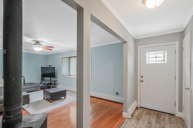 29 Patchogue Rd, Sound Beach, NY 11789 - entrance foyer with light wood finished floors, ornamental molding, ceiling fan, and a wood stove