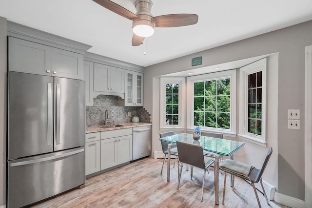 29 Patchogue Rd, Sound Beach, NY 11789 - kitchen featuring stainless steel appliances, gray cabinets, decorative backsplash, light wood-style floors, and light stone countertops