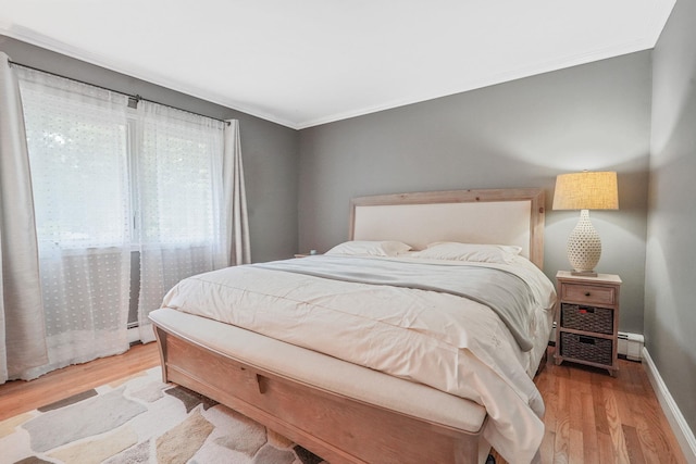 29 Patchogue Rd, Sound Beach, NY 11789 - bedroom with ornamental molding, wood finished floors, a baseboard heating unit, and a baseboard radiator