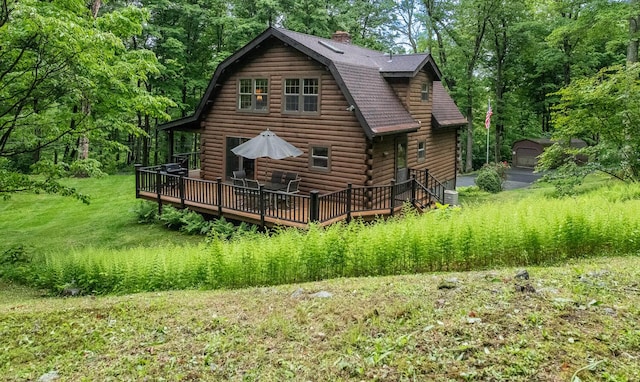 1206 Hollow Rd, Clinton Corners, NY 12514 - back of property with a deck, log siding, a gambrel roof, a garage, and a chimney