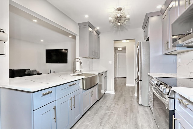 221 Richard Ct, Pomona, NY 10970 - kitchen featuring appliances with stainless steel finishes, a sink, light wood finished floors, light stone countertops, and gray cabinetry
